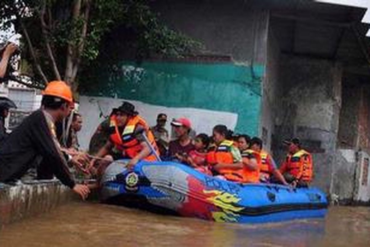 Petugas Satpol PP mengevakuasi warga Kampung Pulo dengan menggunakan perahu karet di Jatinegara Barat Jakarta Timur, Rabu (16/1/2013). Akibat Hujan deras yang melanda Bogor dan Depok menyebabkan muka air di Sungai Ciliwung meluap dan menggenangi pemukiman warga.