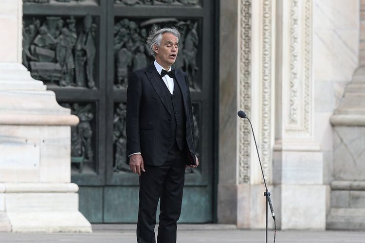 Penyanyi opera dan tenor Italia Andrea Bocelli bernyanyi saat latihan di Piazza del Duomo yang sepi di pusat kota Milan pada 12 April 2020, sebelum pertunjukan malam tanpa publik untuk dunia yang terluka oleh pandemi, selama penguncian negara itu bertujuan untuk membatasi penyebaran infeksi COVID-19, yang disebabkan oleh virus corona.