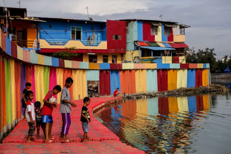 Anak-anak bermain di tepian Danau Sunter di wilayah Kelurahan Sunter Jaya, Kecamatan Tanjung Priok, Jakarta Utara, Minggu (25/3/2018). Pemprov DKI Jakarta melakukan program pengecatan kampung warna-warni di kawasan Danau Sunter untuk memperindah lingkungan sekaligus guna mengubah kesan kumuh kawasan tersebut.