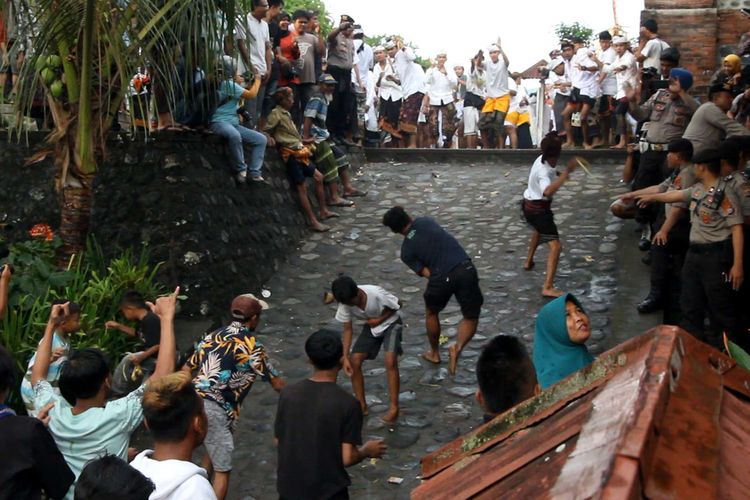 Warga saling lempar dengan ketupat saat tradisi Perang Topat, di  Pura Lingsar, Lombok Barat, Rabu (11/12/2019). Perang topat adalah tradisi di Lombok yang merupakan warisan leluhur dan diyakini merupakan simbol perdamaian dan pemersatu antar umat beragama.