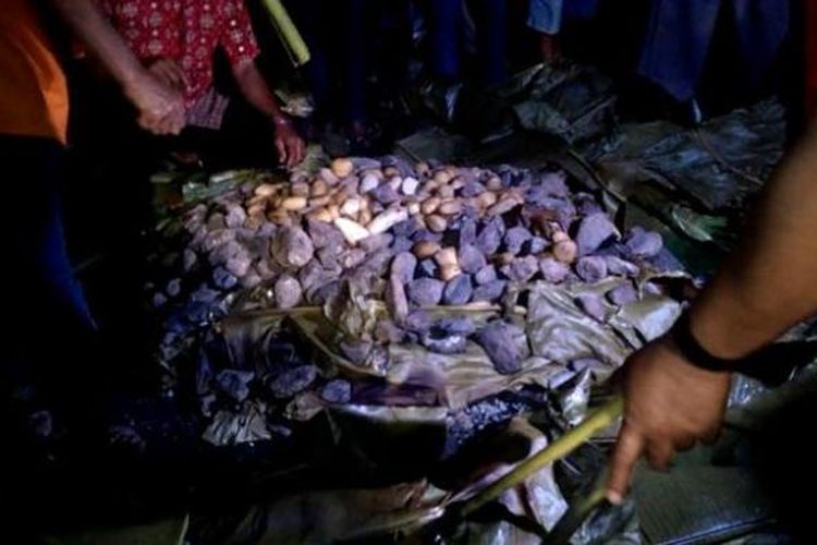 Barapen atau bakar batu, tradisi memasak tertua di Papua, Papua Barat, Kamis (4/9/2014). Singkong, keladi, ikan, dan daging berbungkus aluminium foil dibakar dengan ditindih batu panas.