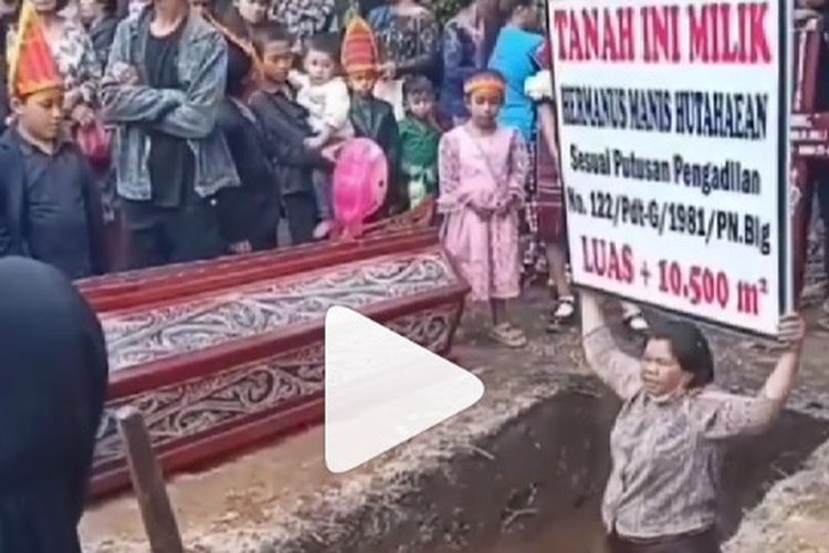 Seorang ibu menghalangi pemakaman kerabatnya di Toba, Sumatera Utara.