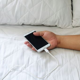 Ilustrasi ponsel atau handphone, Ilustrasi mengisi daya ponsel di kasur.