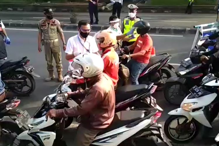 Petugas gabungan PKM Semarang melakukan pengecekan suhu tubuh pengendara di depan pos perbatasan Plamongan, Semarang, Rabu (29/4/2020)