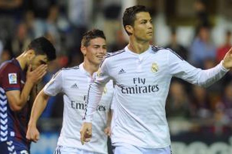Penyerang Real Madrid, Cristiano Ronaldo (kanan), merayakan gol yang dicetaknya ke gawang Eibar pada laga Primera Division di markas Eibar, Sabtu (22/11/2014). Rekan setim Ronaldo, James Rodriguez (tengah), ikut berselebrasi.