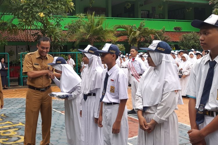 Plt Kadisdik DKI Jakarta Syaefulloh Hidayat saat memberi bantuan seragam sekolah ke siswa yang terdampak banjir di SMPN 207 Kembangan, Jakbar, Senin (6/1/2020).