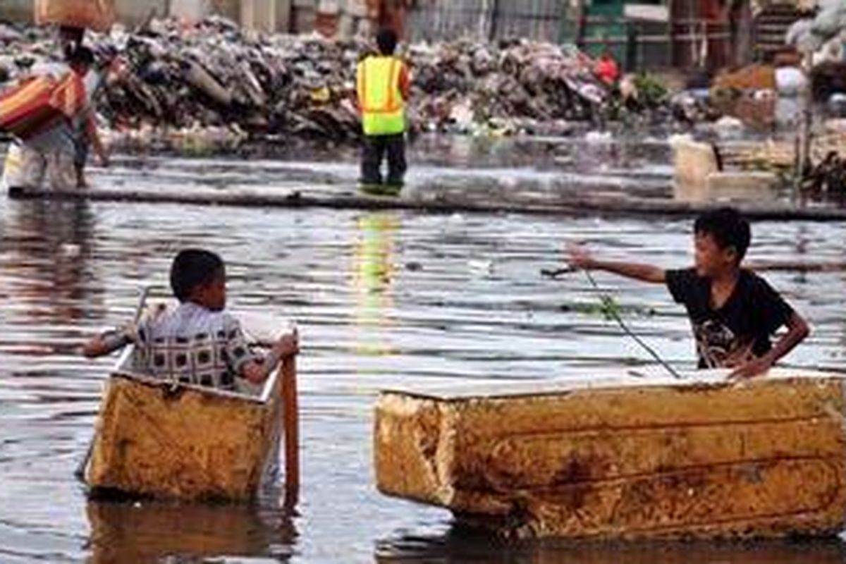 Bocah bermain perahu yang terbuat dari styrofoam di Muara Baru, Jakarta Utara, Kamis (24/01/2013). Mereka bermain di genangan air akibat meluapnya waduk Pluit. 