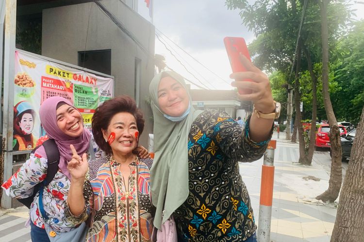 Usai berbagi takjil untuk ojol, ikon kuliner Surabaya Bu Rudy foto bersama masyarakat yang melintasi didepan depotnya di Jalan Dharmahusada Surabaya, Jumat (7/3/2025) sore.