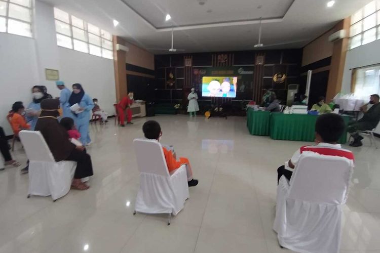 Anak-anak menonton film kartun sebelum disuntik vaksin Covid-19 di RST dr. Soedjono Magelang, Kamis (30/12/2021).
