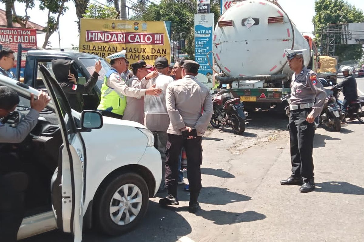 Aparat kepolisian saat mengamankan sekelompok orang yang diduga oknum calo SIM saat menggelar aksi di depan Satpas Singosari, Senin (18/12/2023).
