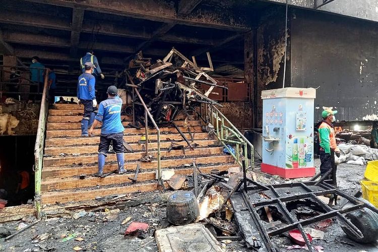 Sejumlah petugas membersihkan sisa-sisa kebakaran Blok C Pasar Minggu pada Minggu (25/4/2021). 