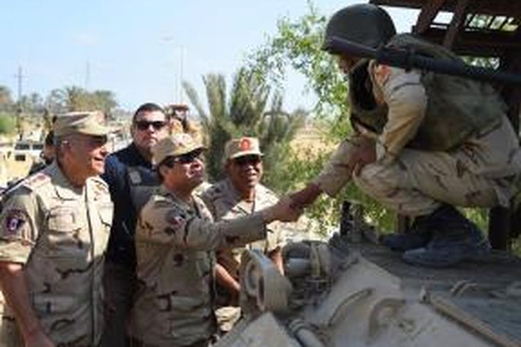 Presiden Mesir Abdel Fattah al-Sisi menyalami seorang prajurit yang bertugas di kawasan bergolak Semenanjung Sinai saat meninjau kawasan tersebut, Sabtu (4/7/2015).