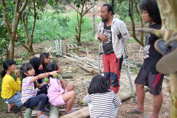 Pristiawan atau sering dipanggil Wawan, sedang berdiskusi dengan anak-anak masyarakat desa. 