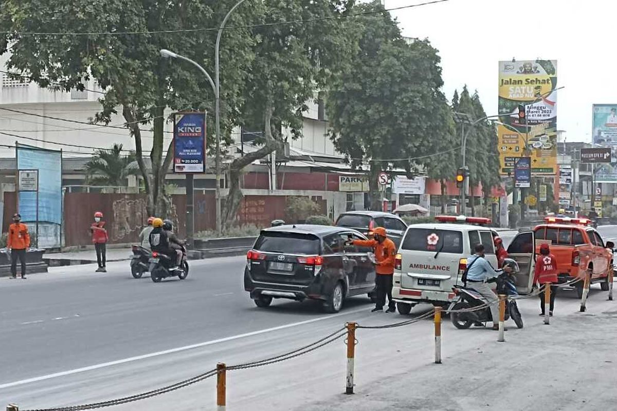 Petugas Badan Penanggulangan Bencana Daerah (BPBD) Kota Magelang, Jawa Tengah, dan PMI membagikan masker kepada masyarakat di kawasan Alun-alun Kota Magelang dan sekitarnya. Aksi tersebut dilakukan karena saat ini sedang terjadi hujan abu yang berasal dari erupsi Gunung Merapi di wilayah Kabupaten Magelang, Sabtu (11/3/2023) siang.