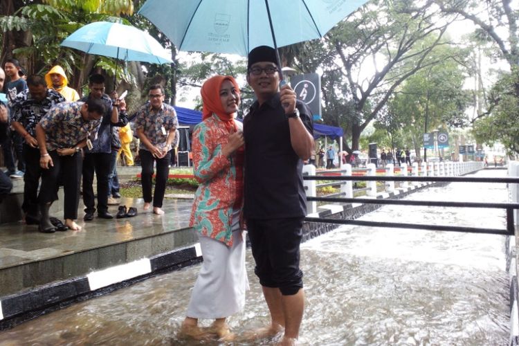 Ridwan Kamil bersama istrinya Atalia Praratya saat meninjau suasana di Sungai Cikapayang, Bandung. 