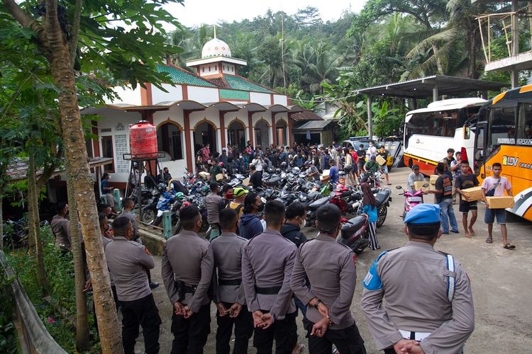 Anggota Polisi berjaga saat warga yang sempat ditahan tiba di halaman masjid Desa Wadas, Bener, Purworejo, Jawa Tengah, Rabu (9/2/2022). Sebanyak 64 warga Desa Wadas dibebaskan oleh pihak kepolisian terkait aksi penolakan pembangunan Bendungan Bener. ANTARA FOTO/Hendra Nurdiyansyah/wsj.