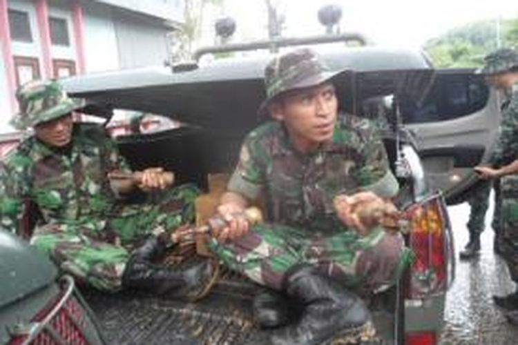 Aparat TNI mengamankan dua peti mortir dan bahan peledak yang ditemukan warga di kawasan Kampung Kolam, Dusun Ahuru desa Batu Merah ecamatan Sirimau, Ambon, Jumat (6/12/2013). tampak anggota TNI sedang memegang mortir ditangannya