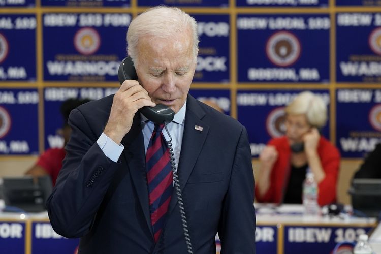 Presiden Amerika Serikat Joe Biden berbicara melalui telepon saat mengunjungi International Brotherhood of Electrical Workers Local 103 di Boston, 2 Desember 2022.