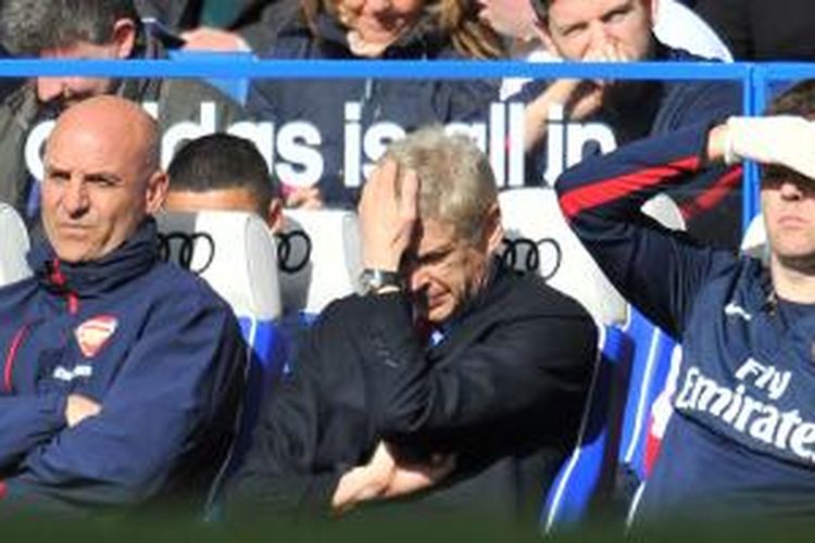 Manajer Arsenal, Arsene Wenger (tengah), memegang jidat saat melihat timnya digasak Chelsea 0-6 pada laga Premier League di Stamford Bridge, Sabtu (22/3/2014).