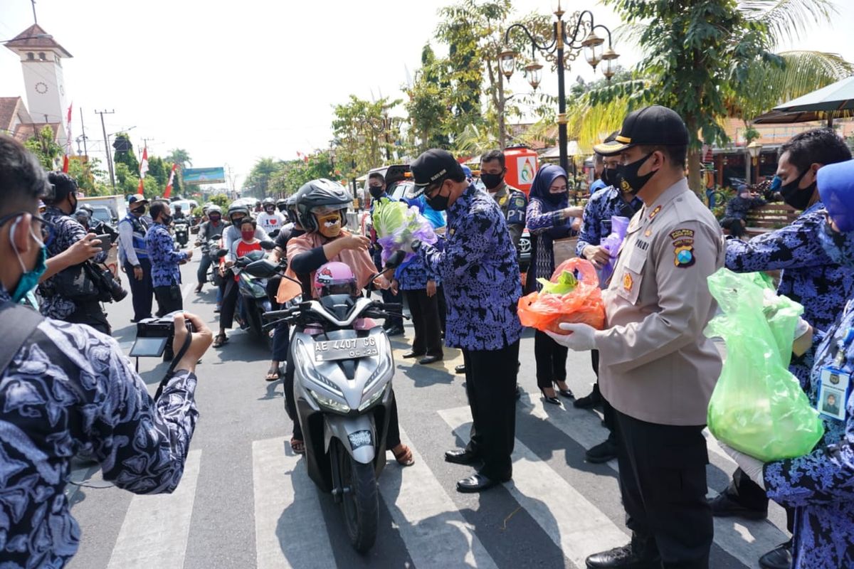 Wali Kota Madiun, Maidi didampingi Kapolres Madiun Kota, AKBP R Bobby Aria Prakasa membagikan sayuran, telur dan susu gratis bagi warga yang melintas di Jalan Pahlawan Kota Madiun, Selasa (21/7/2020)