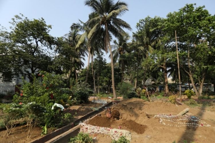 Seorang asisten Sayyed Munir Kamruddin, seorang penggali kubur, menyiapkan kuburan untuk penguburan korban Covid-19 di sebuah pemakaman di Mumbai, India 28 April 2021.