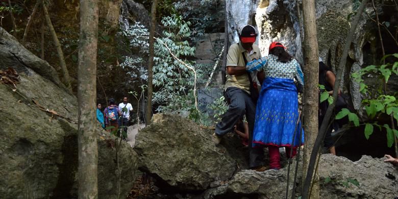 Seorang pemandu wisata di Labuan Bajo membantu wisatawan mancanegara untuk melewati batuan karang di obyek wisata Goa Batu Cermin, Desa Batu Cermin, Kecamatan Labuan Bajo, Manggarai Barat, Nusa Tenggara Timur, Rabu (18/11/2015). Dalam penelitian, Theodore Verhoven menyimpulkan bahwa Pulau Flores dulunya berada di dasar laut.