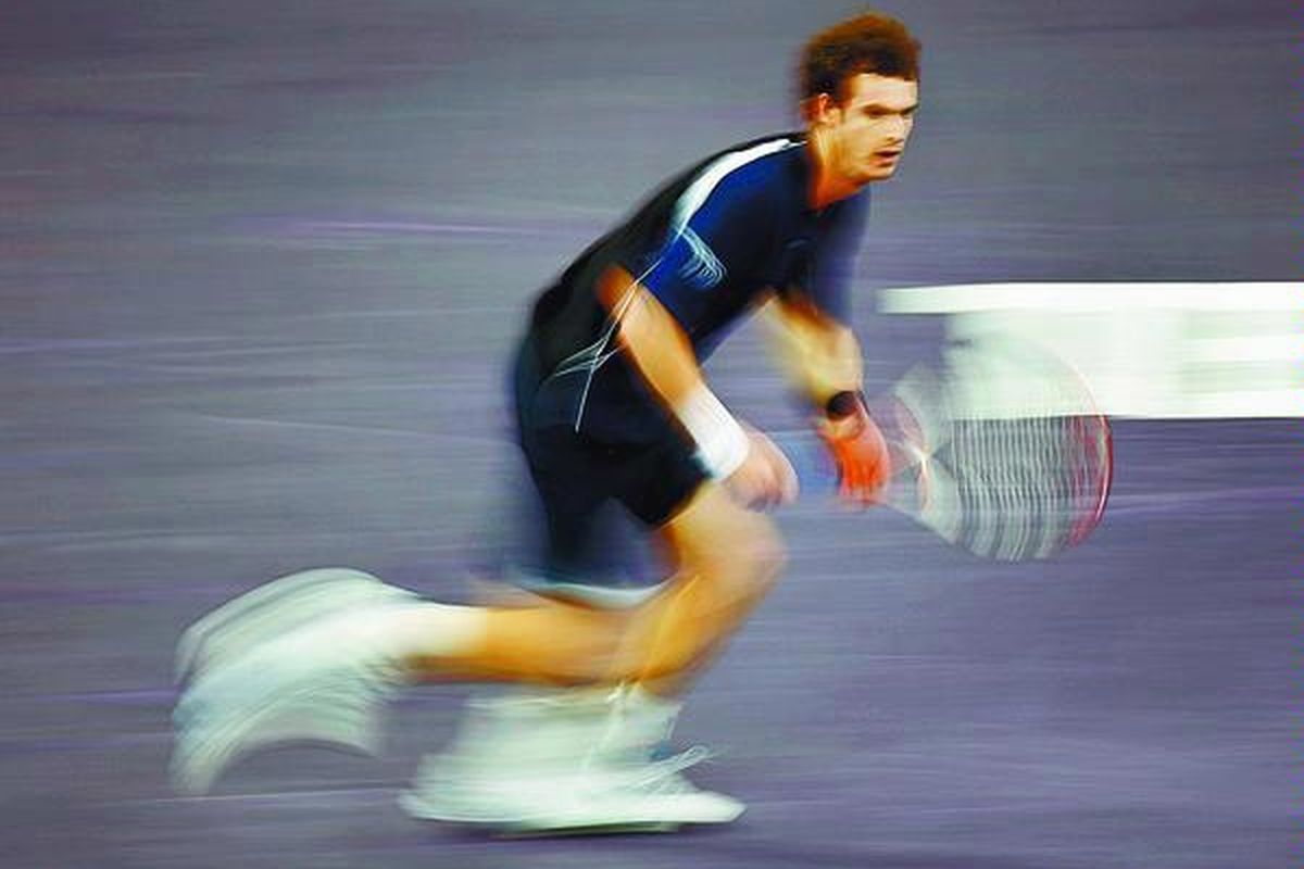 Petenis Inggris, Andy Murray, berkelebat saat menutup daerah pertahanannya dari serangan petenis Perancis, Gilles Simon, pada pertandingan Masters Cup di Stadion Qi Zhong, Shanghai, China, Rabu (12/11).  