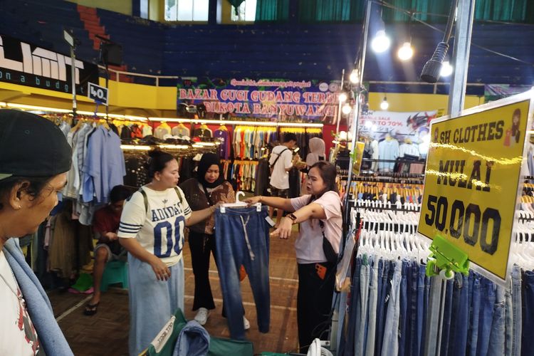 Pengunjung bazar thrifting di Banyuwangi sedang memilih pakaian yang akan dibeli. 