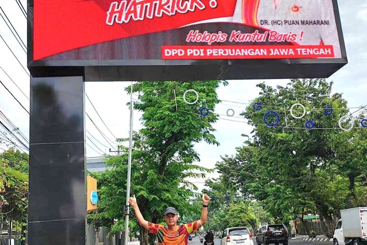 Gubernur Jateng Ganjar Pranowo berswafoto di bawah baliho PDIP yang terletak di Jalan Gajahmada, Semarang, Minggu (2/10/2022).