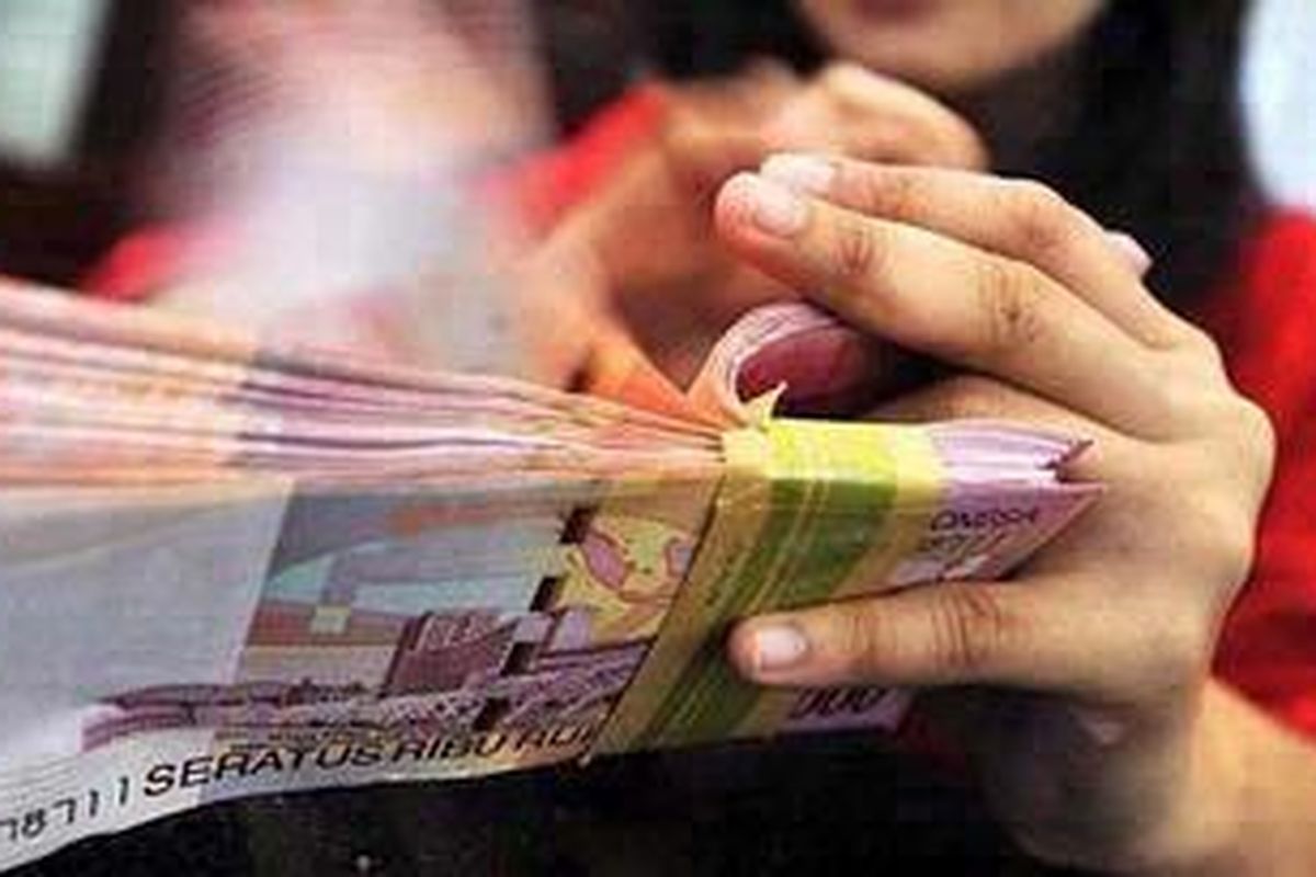 Pegawai bank menghitung uang pecahan Rp 100.000 di Kantor Bank OCBC NISP, Jakarta, Senin (4/4). 