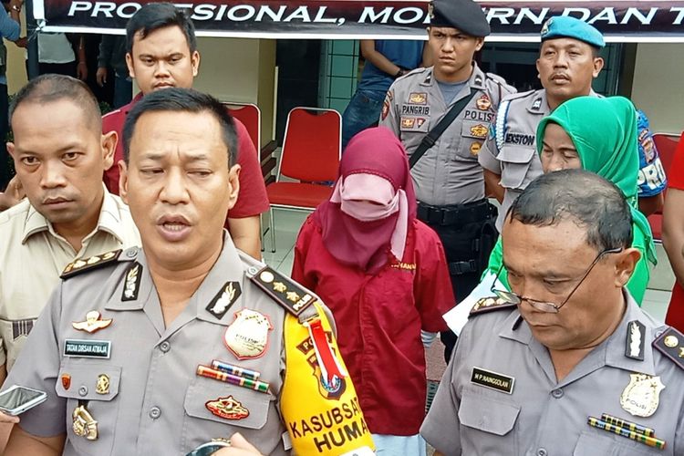 Kepala Bidang Humas Polda Sumut AKBP Tatan Dirsan Atmaja dengan dengan pelaku Himma di belakangnya (kemeja dan kerudung merah), Minggu (20/5/2018)