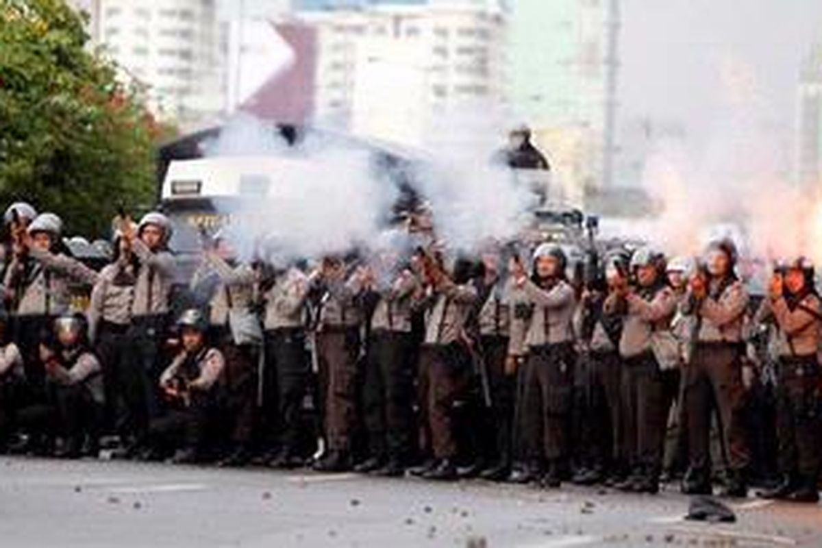 Polisi menembakkan gas air mata ke arah mahasiswa yang berunjuk rasa di depan Gedung DPR RI, Jalan Gatot Subroto, Senayan, Jakarta, Kamis (29/3/2012). Aksi ini kembali berujung bentrok ketika mahasiswa merusak pagar untuk masuk ke dalam gedung DPR RI.