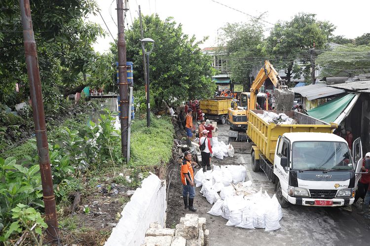 Sebanyak 40 Satgas Dinas Sumber Daya Air dan Bina Marga (DSDABM) Kota Surabaya diturunkan untuk melakukan perbaikan usai pelapis tanggul sungai di kawasan Kembang Kuning jebol pada Jumat (28/3/2023).