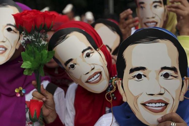 Relawan Jokowi dan Jusuf Kalla membagi-bagikan bunga dan stiker kepada pengendara yang melintas di kawasan Bundaran Hotel Indonesia, Jakarta, Rabu (15/10). Dukukan relawan Jokowi dan Jusuf Kalla muncul kembali menjelang hari pelantikan sebagai presiden dan wakil presiden. 