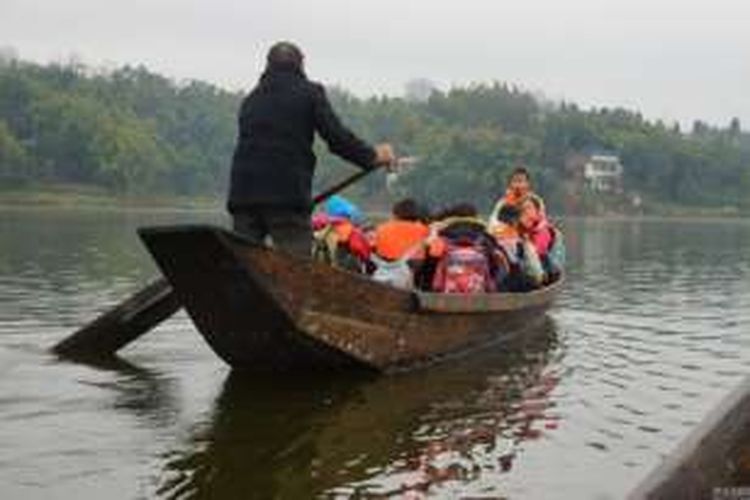 Li Chongsu (60), selama 10 tahun terakhir mendayung perahunya untuk menjemput murid-muridnya yang kesulitan menuju ke sekolah karena tinggal di seberang sebuah bendungan.