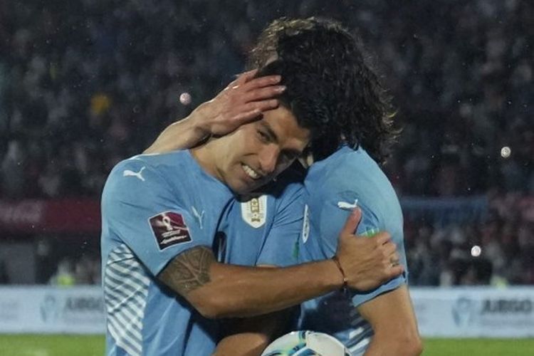Duo penyerang Uruguay, Luis Suarez (kiri) dan Edinson Cavani (kanan) berpelukan setelah mengalahkan Peru dalam lanjutan Kualifikasi Piala Dunia 2022 Zona Amerika Selatan di Stadion Centenario, Montevideo, pada Jumat (25/3/2022) pagi WIB.
