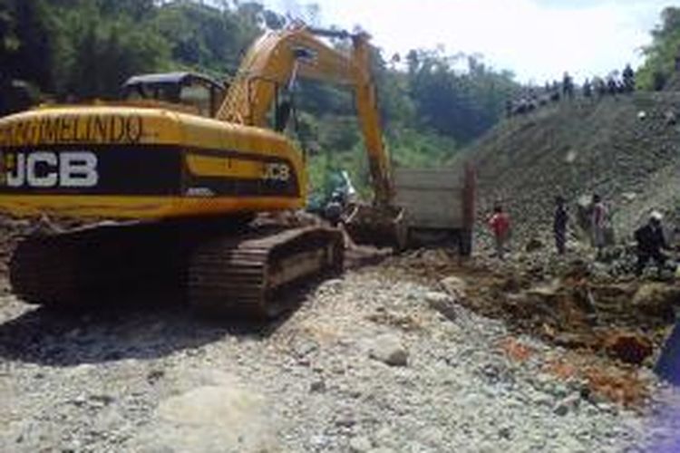 Sebuah alat berat mengevakuasi truk yang tertimbun longsor di bantaran kali Pabelang, Dusun Wonogiri, Desa Kepuhan, Kecamatan Sawangan, Kabupaten Magelang, Senin (25/8/2014).
 