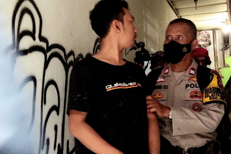 AH (27) alias C, dibawa personel Polsek Palmerah yang tengah memburu pengguna, pengedar, hingga bandar narkoba di kampung rawan peredaran narkoba, Kampung Boncos, di Kota Bambu Selatan, Palmerah, Jakarta Barat, pada Rabu (2/11/2022) sore.