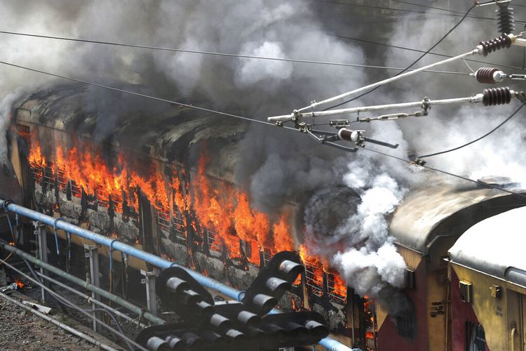 Kobaran api dari kereta api yang dibakar oleh pengunjuk rasa di stasiun kereta api Secundrabad di Hyderabad, India, Jumat, 17 Juni 2022. 