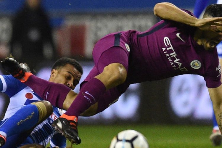 Striker Manchester City, Sergio Aguero (kanan), berduel dengan bek Wigan Athletic, Nathan Byrne, dalam laga babak kelima Piala FA di Stadion DW, Wigan, Inggris, pada 19 Februari 2018.