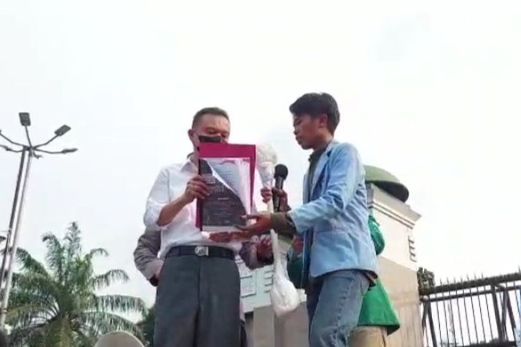 Wakil Ketua DPR Sufmi Dasco Ahmad saat menerima korek kuping raksasa dari perwakilan BEM SI di depan gerbang MPR/DPR, Jalan Gatot Subroto, Jakarta, Senin (11/4/2022).