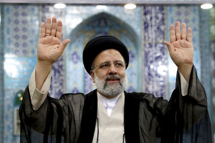 Calon presiden Iran Ebrahim Raisi melambai ke media setelah memberikan suaranya di tempat pemungutan suara di Teheran, Iran, Jumat (18/6/2021). Iran menggelar pemungutan suara dalam pemilihan presiden pada Jumat.