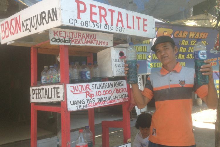 Mbah Minto (58), memperlihatkan BBM jenis Pertalite ukuran 1 liter di kedai Bensin Kejujuran di Jalan Duwet, Beringin, Kota Semarang, Selasa (18/9/2018).