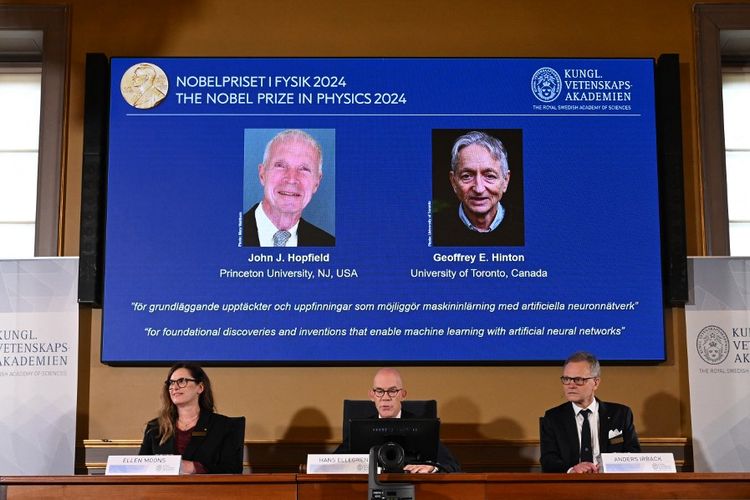 Sebuah layar menunjukkan para pemenang Hadiah Nobel Fisika 2024, fisikawan AS John J Hopfield (kiri) dan ilmuwan komputer dan psikolog kognitif Kanada-Inggris Geoffrey E Hinton di atas Ketua Komite Nobel Fisika Ellen Moons, Sekretaris Jenderal Akademi Ilmu Pengetahuan Kerajaan Swedia Hans Ellegren, dan Anggota Komite Nobel Fisika Anders Irbaeck saat mengumumkan di Akademi Ilmu Pengetahuan Kerajaan Swedia di Stockholm, Swedia, pada tanggal 8 Oktober 2024. John Hopfield dari Amerika Serikat dan Geoffrey Hinton dari Inggris-Kanada memenangkan Hadiah Nobel Fisika pada 8 Oktober 2024 untuk karya perintis dalam pengembangan kecerdasan buatan. 
