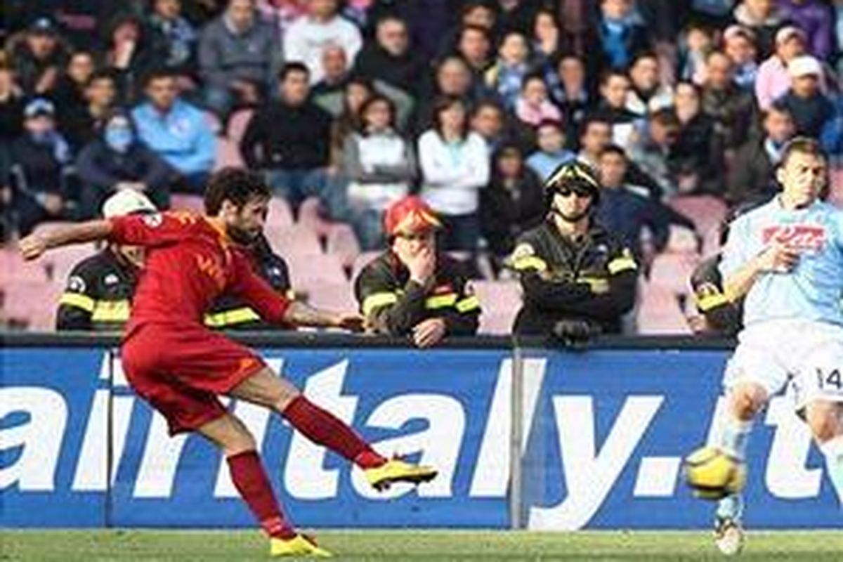 Penyerang AS Roma, Mirko Vucinic, melakukan tendangan yang menghasilkan gol. AS Roma sempat unggul, namun akhirnya ditahan Napoli 2-2.