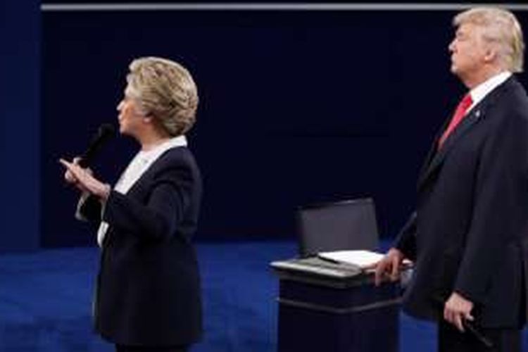 Hillary Clinton dan Donald Trump dalam debat kedua mereka sebagai kandidat Presiden AS pada Minggu (9/10/2016) malam waktu setempat di Universitas Washington, St Louis, Missouri