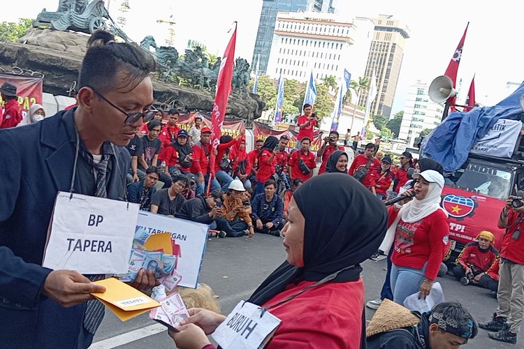 Aksi Teatrikal BP Tapera menarik iuran kepada masyarakat dalam aksi di Patung Arjuna Wijaya, Jakarta Pusat, Kamis (27/6/2024)