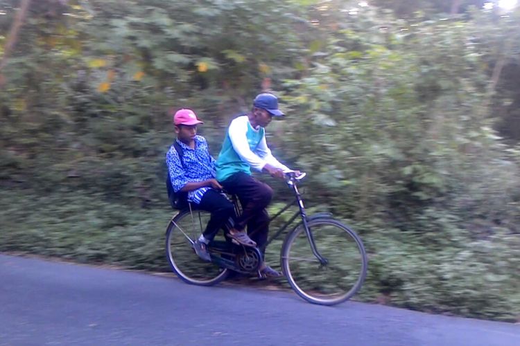 Sudiyono bersepeda belasan kilometer hanya untuk membawa Yuli ke SLB. Jalan yang dilintasi beraspal halus, tetapi berbukit dan lembah, juga padat kendaraan dan orang lewat. Banyak sawah dan ladang sepanjang perjalanan yang dilintasi.