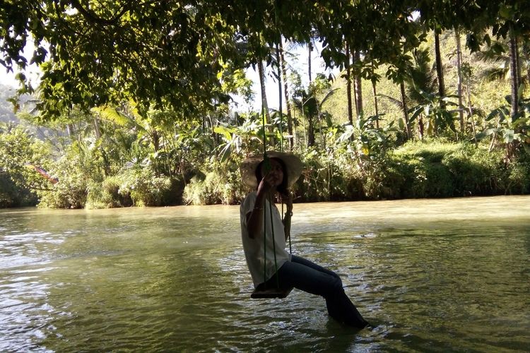 Pengunjung bermain di ayunan Sungai Maron