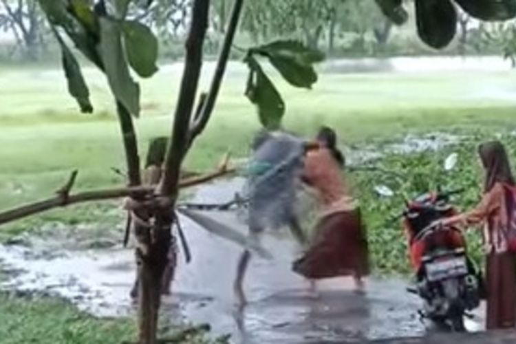 Tangkapan layar video viral seorang pria memukul dan membanting siswi di Nganjuk